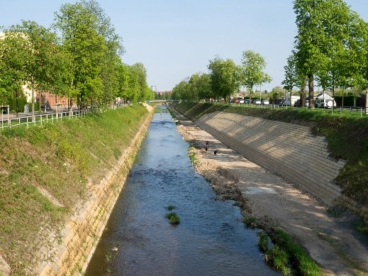 View of an urban stream flowing in an artificial bed.
