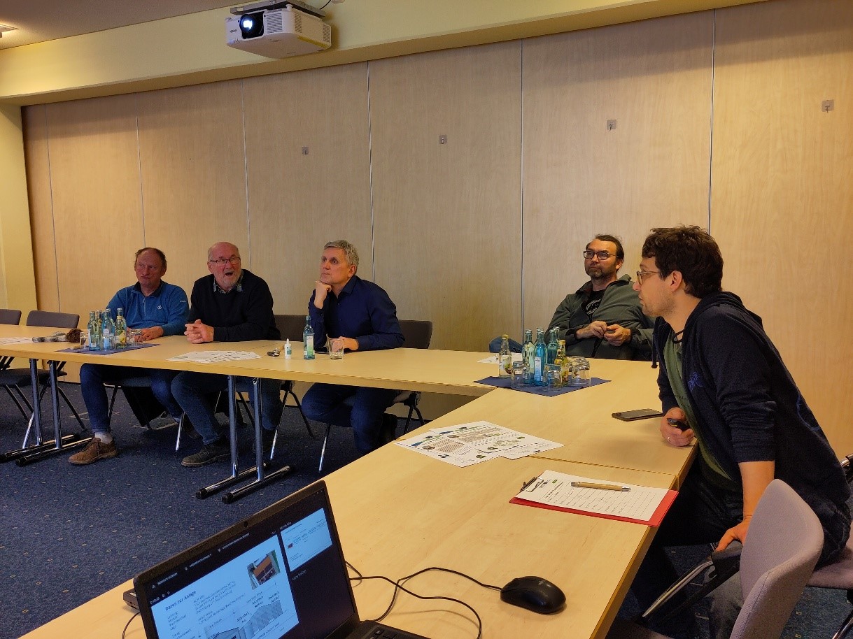 Five men and members of JETA sitting at tables in a conference room in active conversation